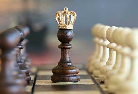 Chess pawn wearing a gold crown